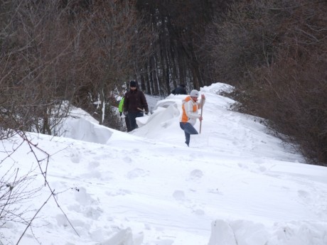 Önkéntesek dolgoznak a 2 méteres hófal mellett